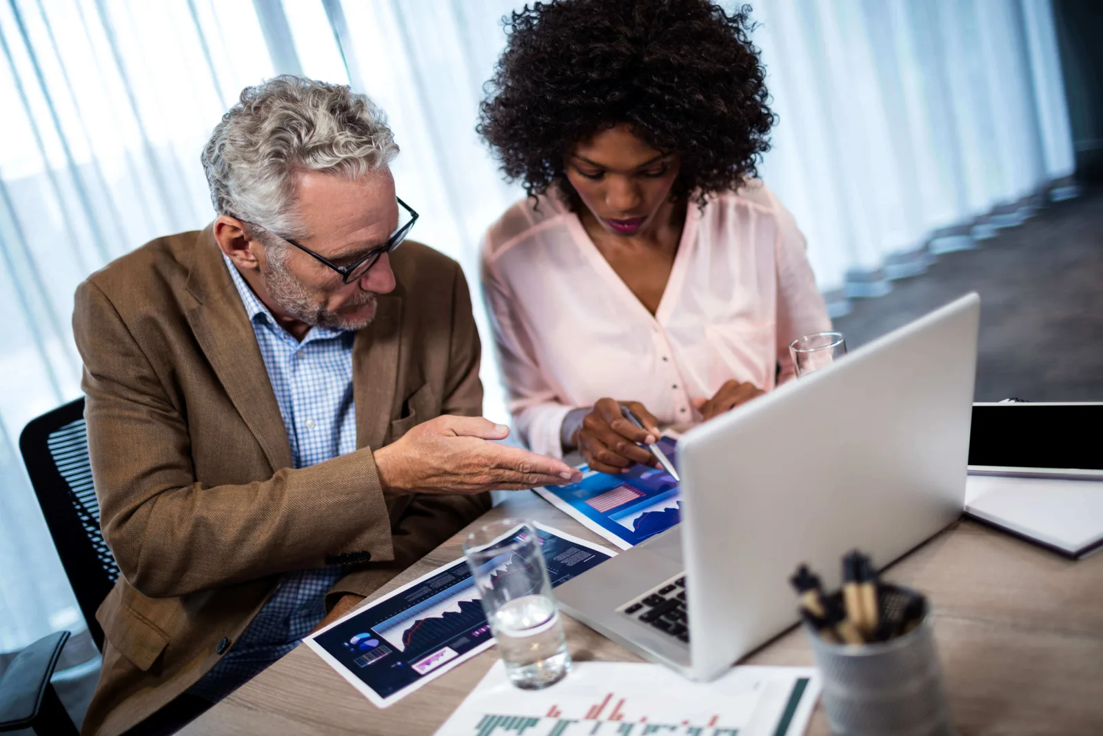 Two businesspeople working on a computer at office