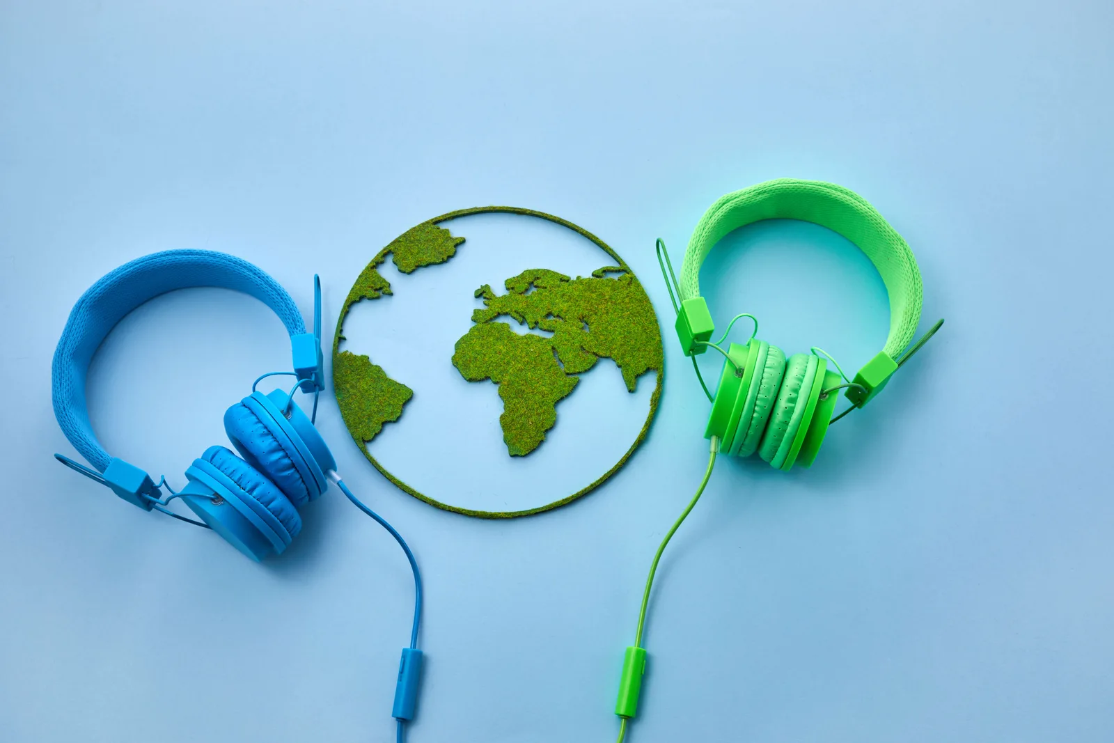 World music day concept. Stereo headphone and a globe on a blue background.