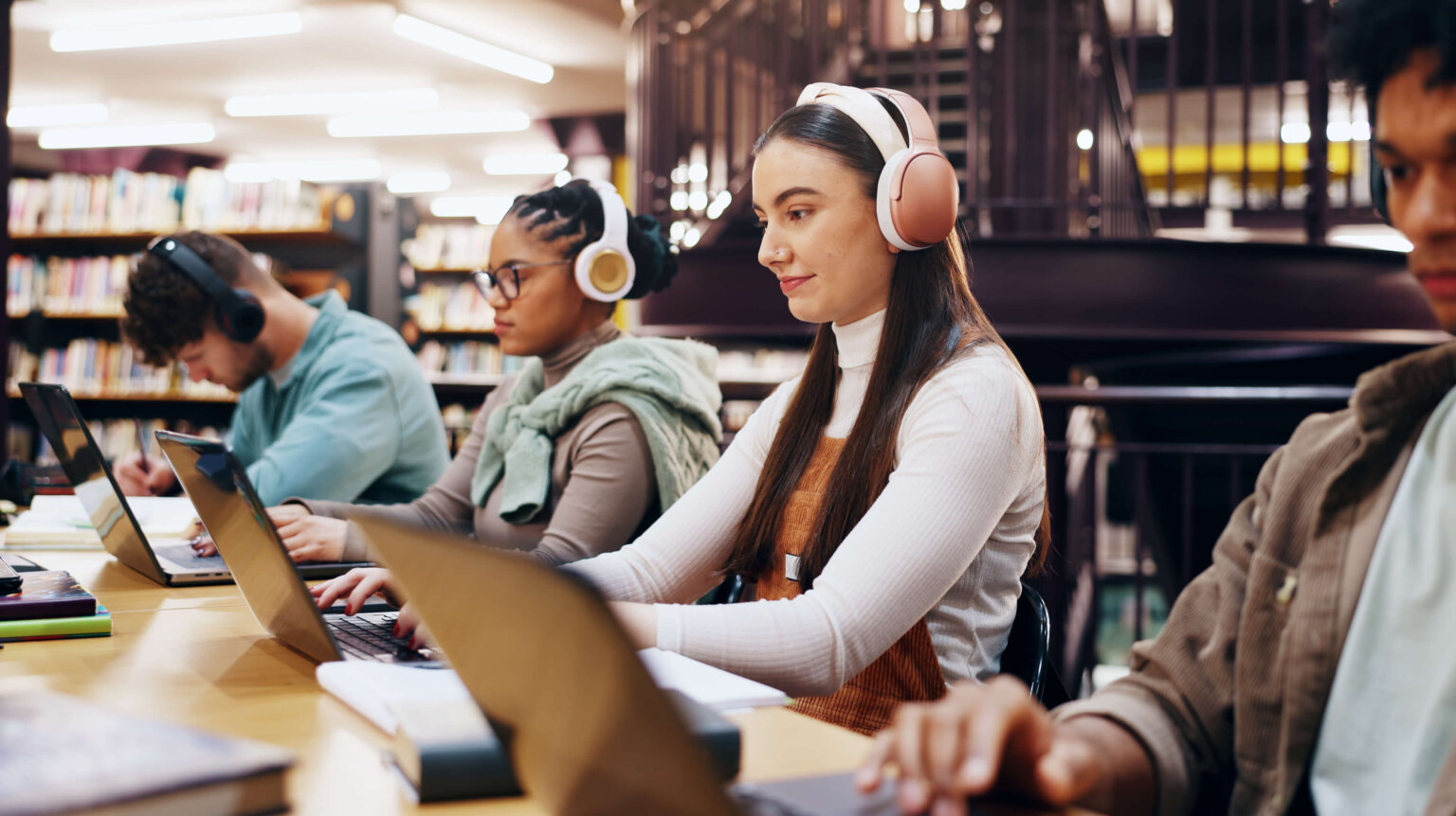 People, studying and laptop in library with headphones, planning and working on research assignment.