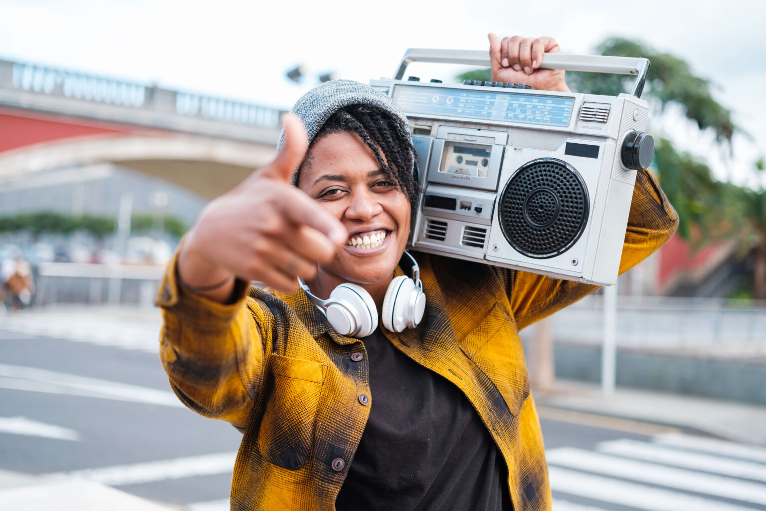 Woman singing hip-hop with the radio on her shoulder.