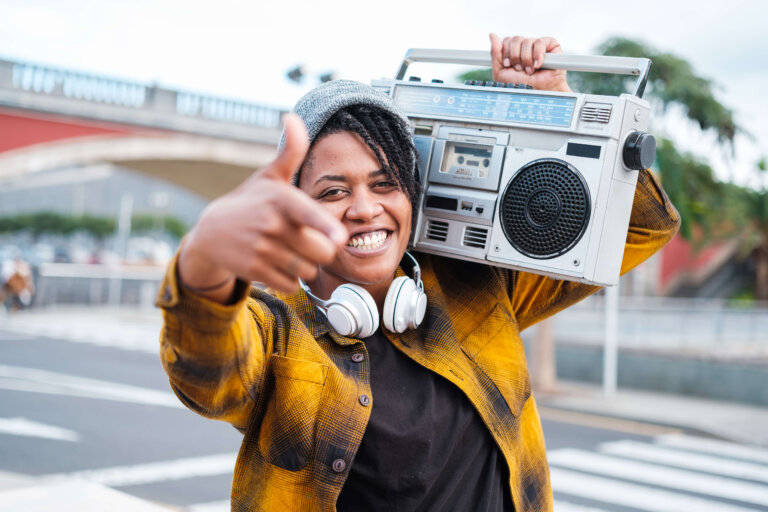 Woman singing hip-hop with the radio on her shoulder.