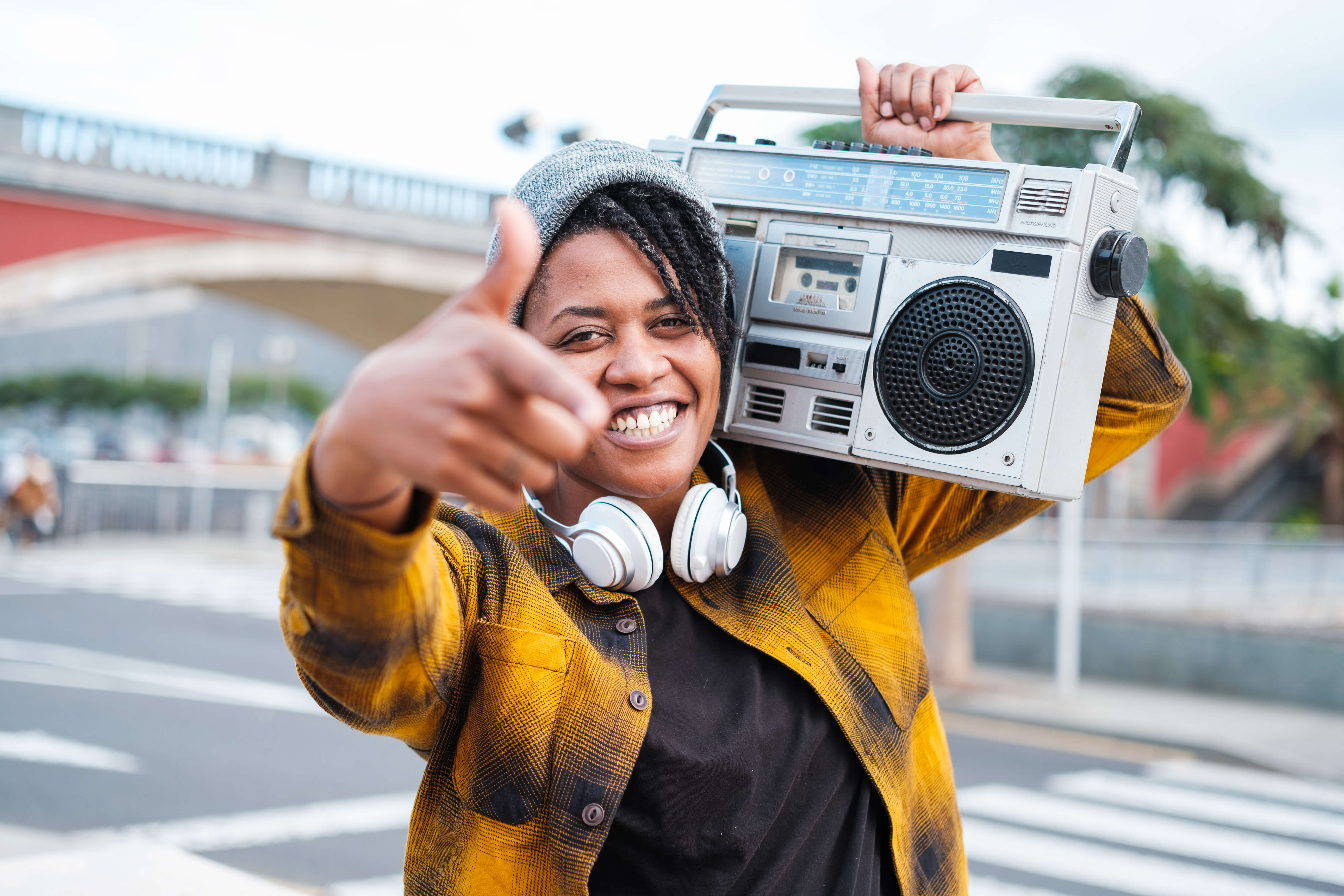 Woman singing hip-hop with the radio on her shoulder.