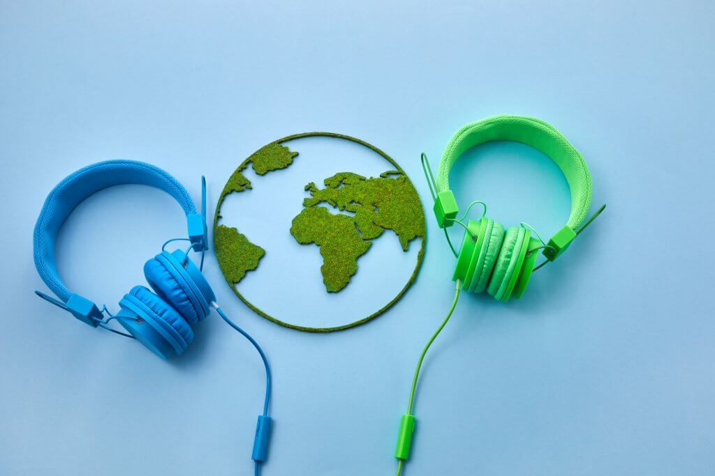 World music day concept. Stereo headphone and a globe on a blue background.