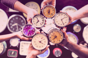 Many different clock held by multicultural hans