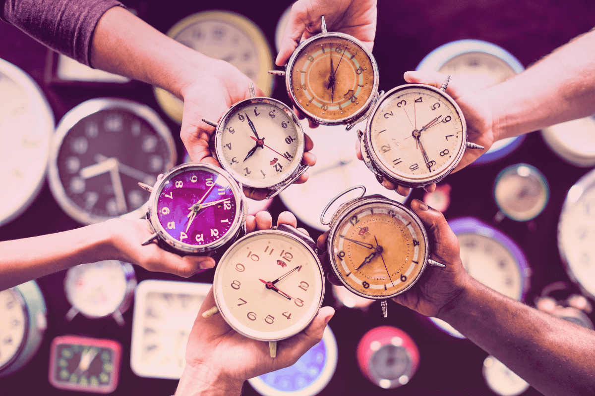 Many different clock held by multicultural hans