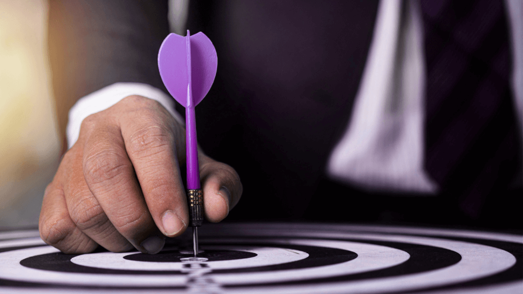 c businessman placing a purple dart in the bullseye of a target, representing precision, goal achievement, and strategic business focus.